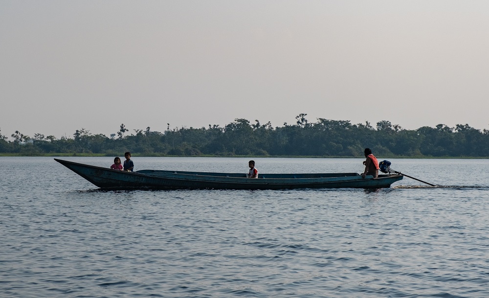 Four people are sitting on a boat. 